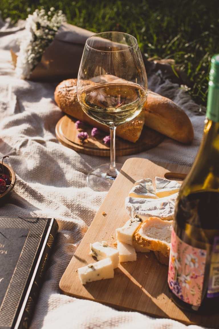 Picnic with wine, cheese platter, snacks for Valentine's day date.